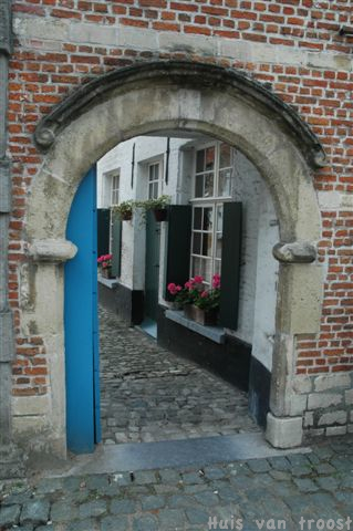 Foto - Door poort huis met gerianiums
